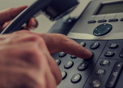 hand pressing numbers on an office phone